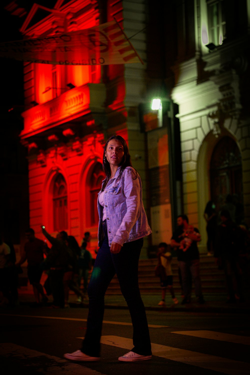 a woman walking down a street at night