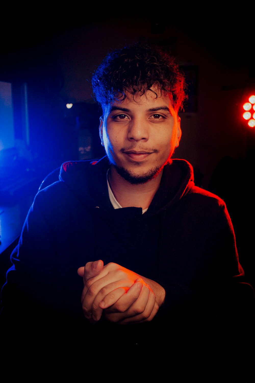 a man in a dark room with a red and blue light