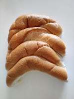 Soft, round dinner rolls arranged neatly on a bright yellow cloth.