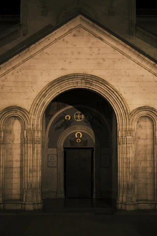 A carved stone doorway illuminated by turquoise and gold light, evoking ancient Mexican temples.