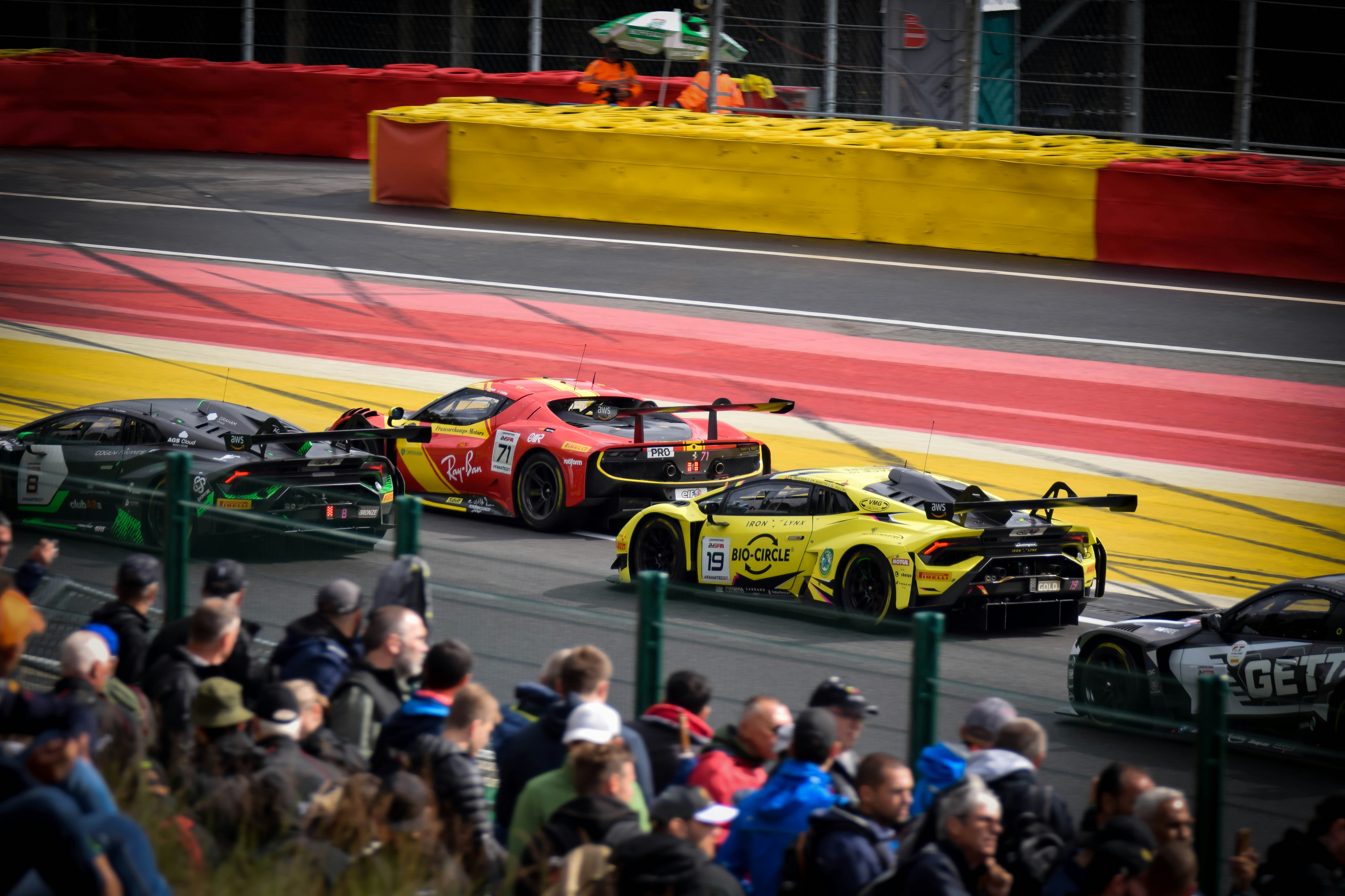 dois carros de corrida dirigindo em uma pista de corrida