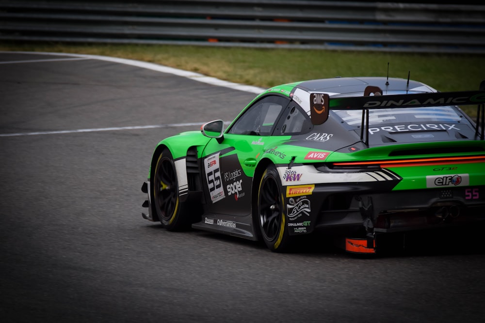 a green race car driving on a race track