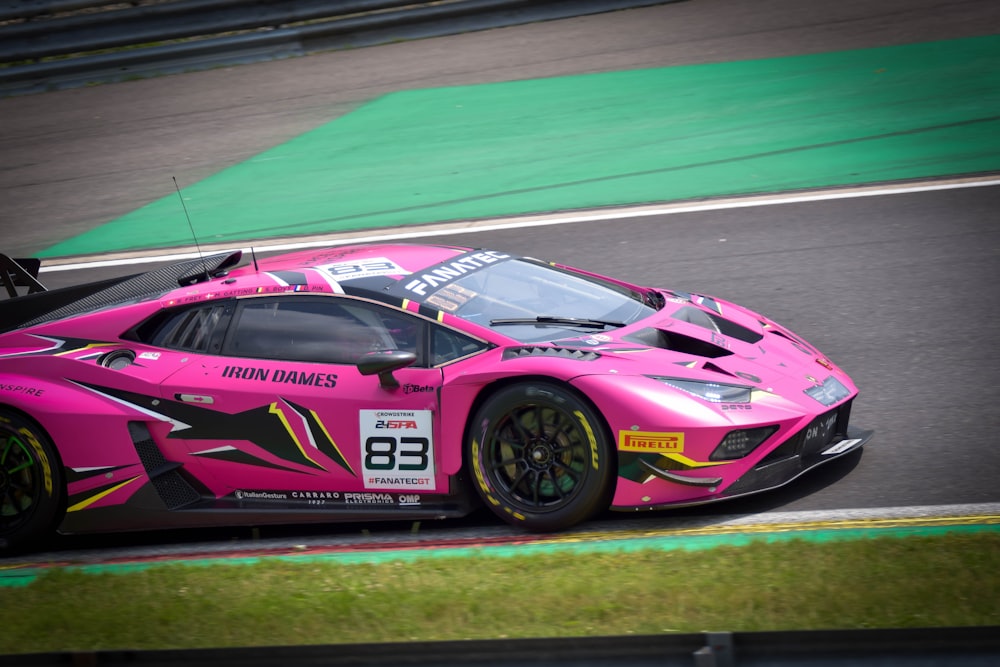 a pink sports car driving on a race track