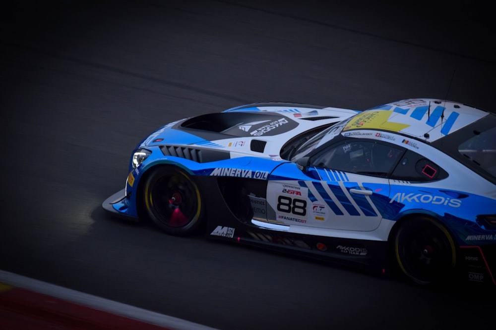 a blue and white car driving on a race track