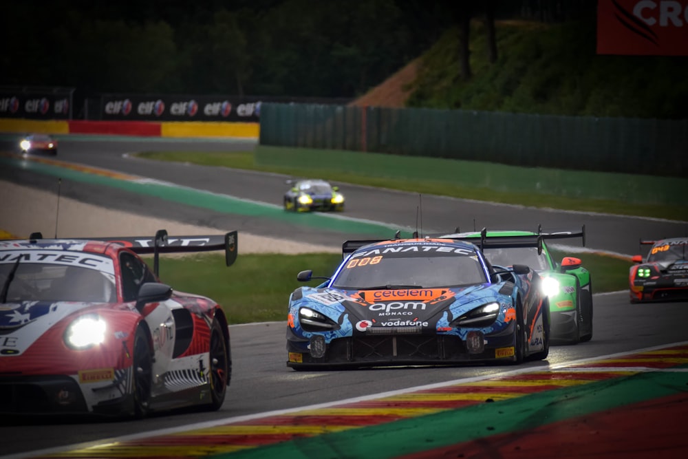 a group of racing cars driving down a race track