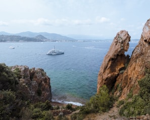 Aerial view of a yacht anchored near a secluded Pattaya cove surrounded by emerald green sea.