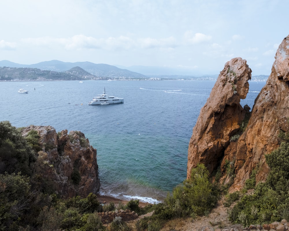 a boat is in the water near some rocks