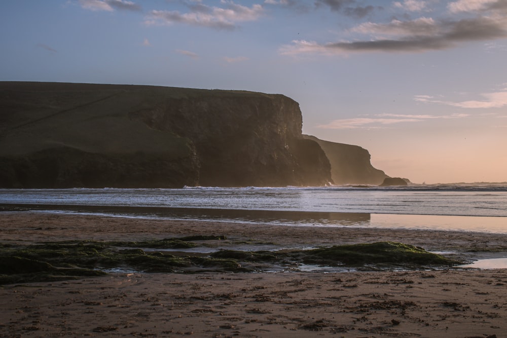 a person walking on a beach with a surfboard