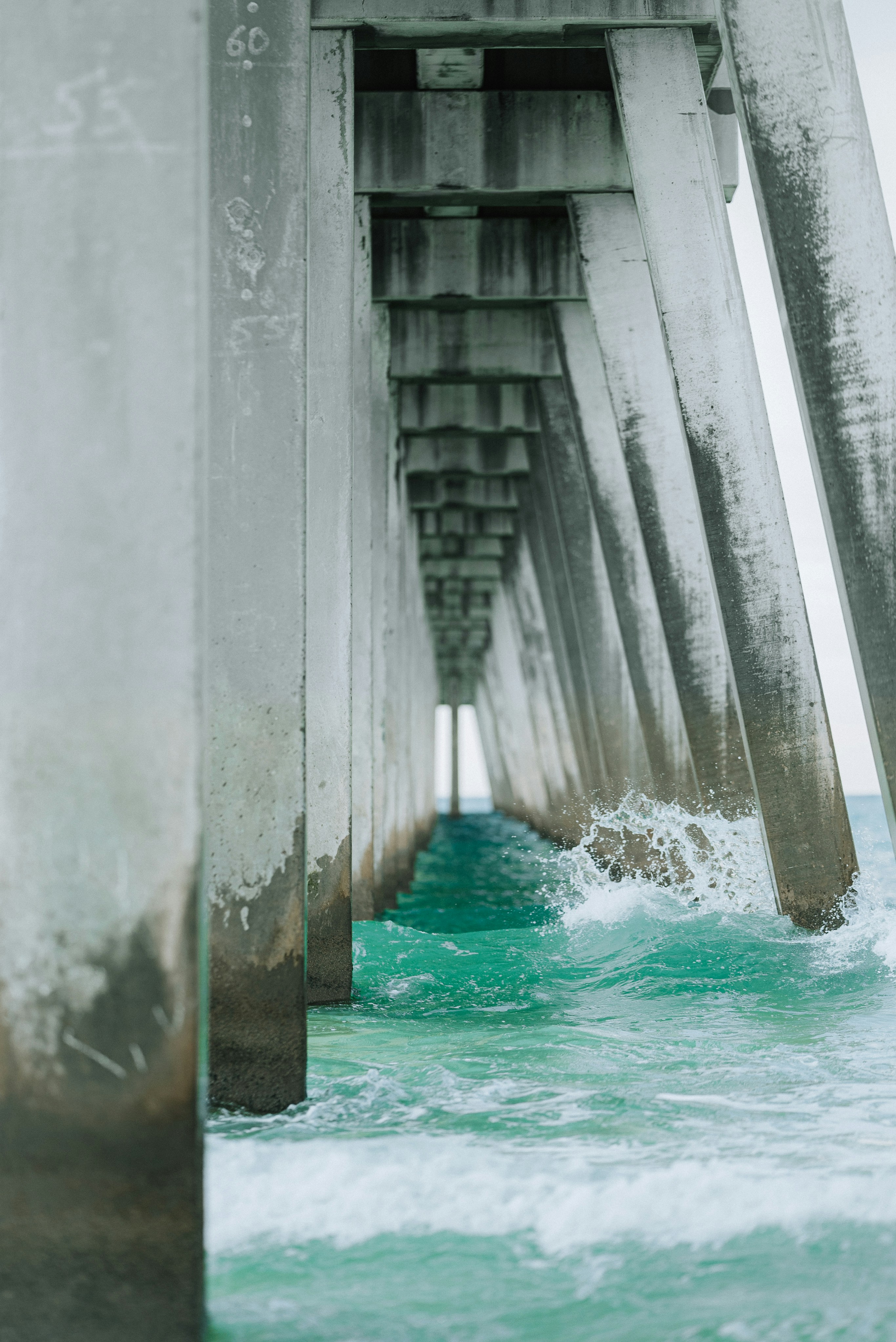 the underside of a bridge with water underneath it