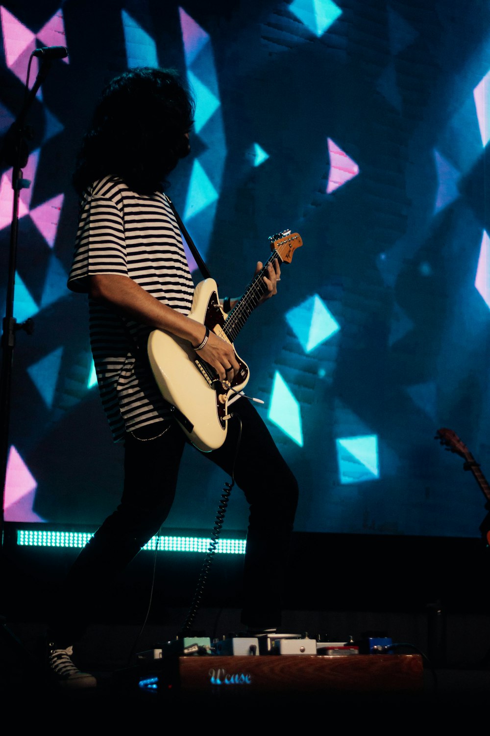 a person playing a guitar on a stage