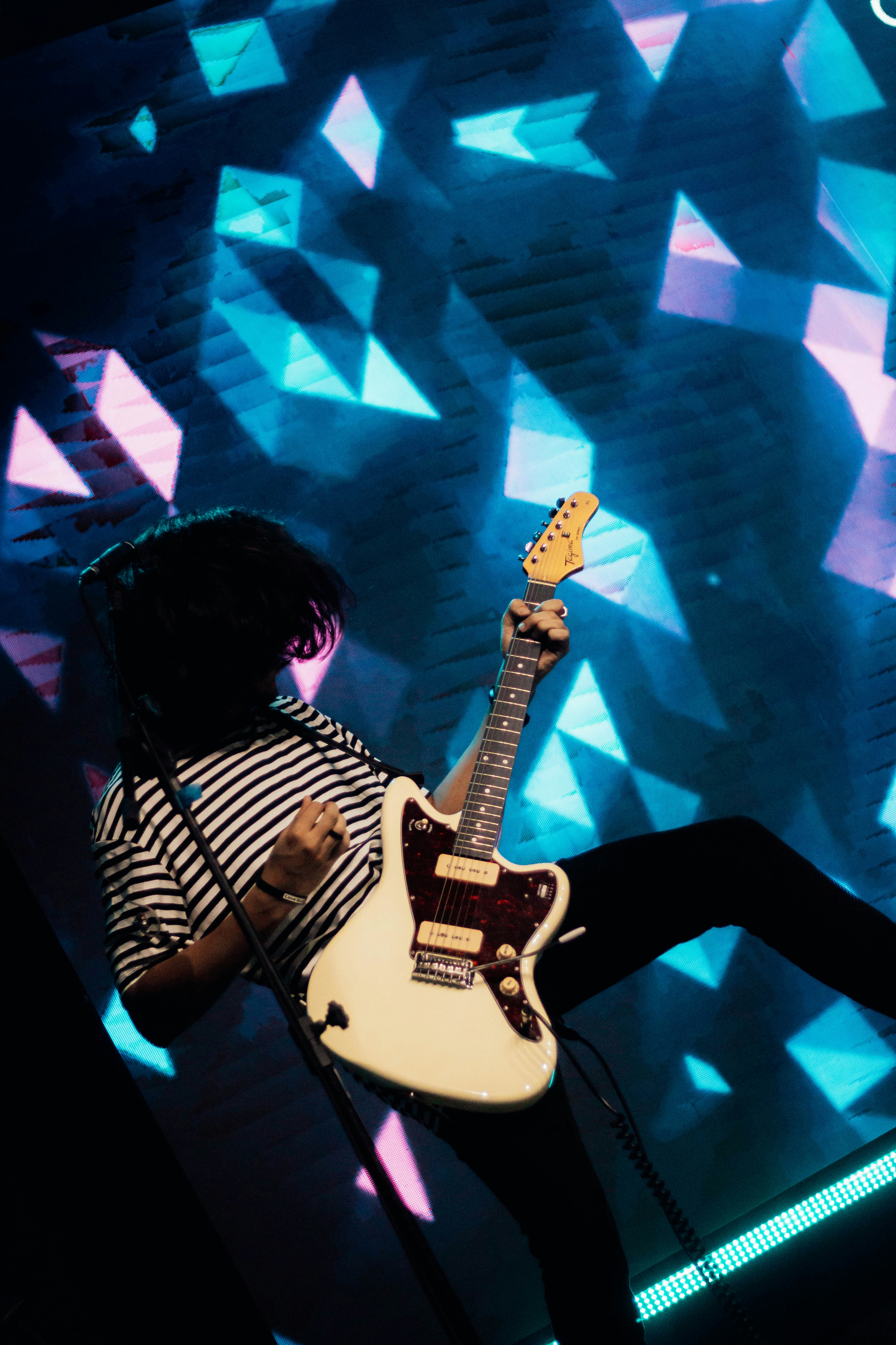 a person with a guitar on a stage