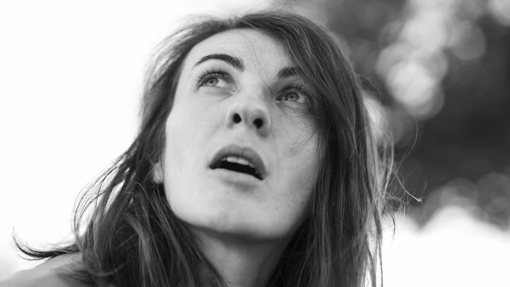 Una foto in bianco e nero di una donna che guarda in alto