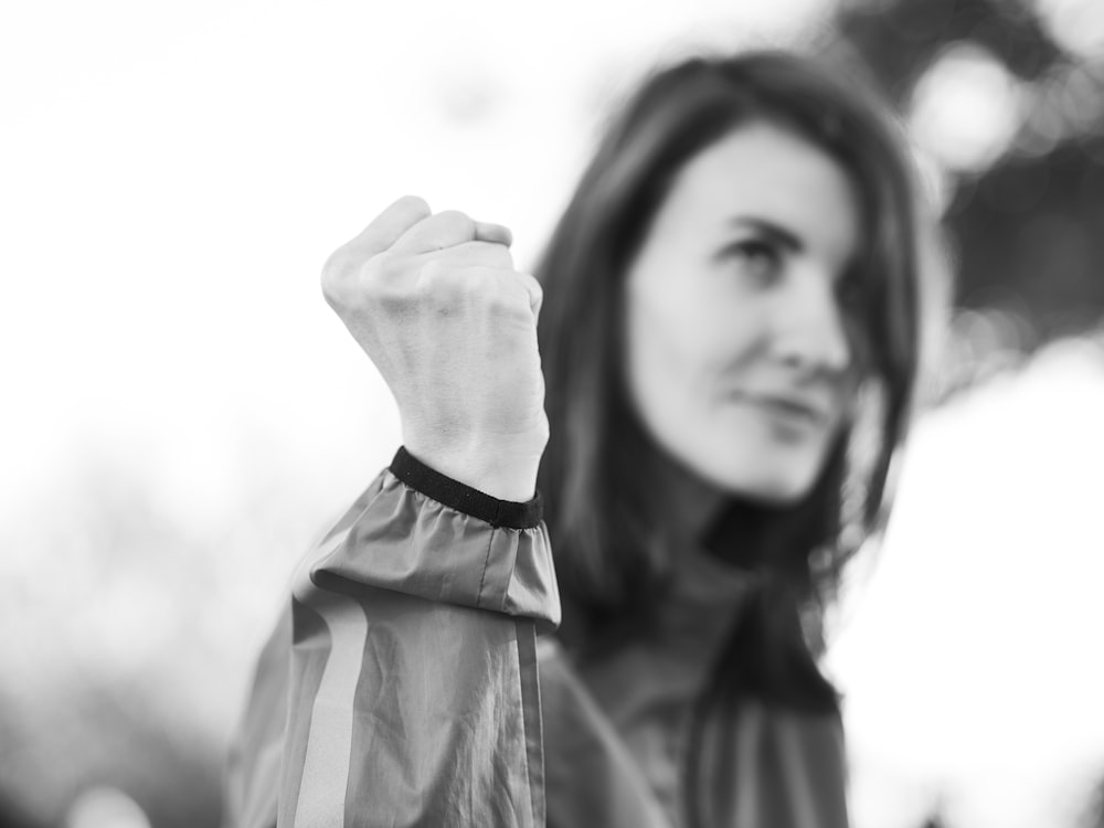 a black and white photo of a woman raising her fist
