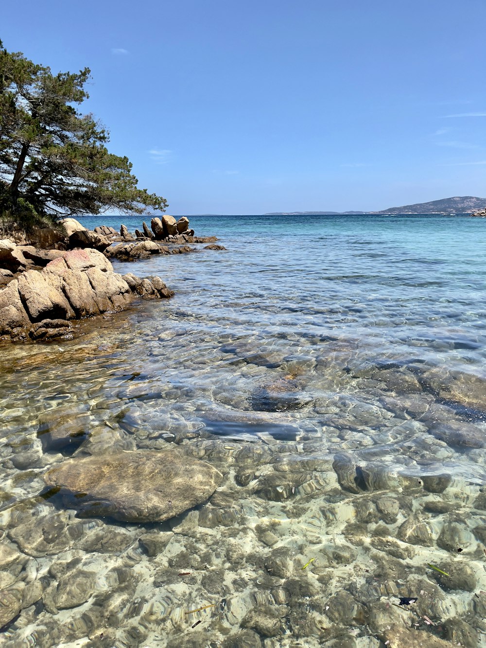 uno specchio d'acqua circondato da rocce e alberi