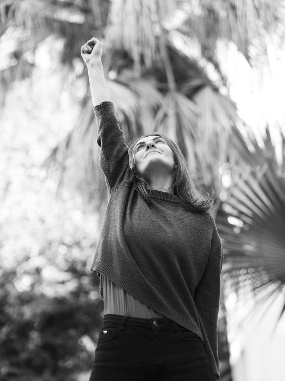 a woman in a black and white photo raising her arms in the air