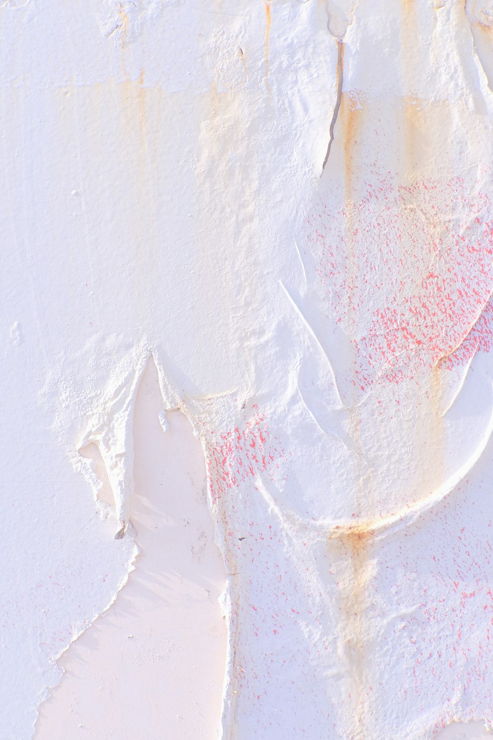 a close up of a white wall with red paint