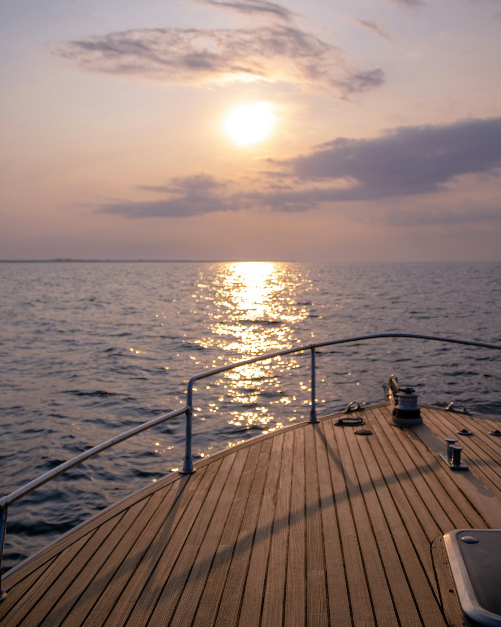 the sun is setting over the water on a boat