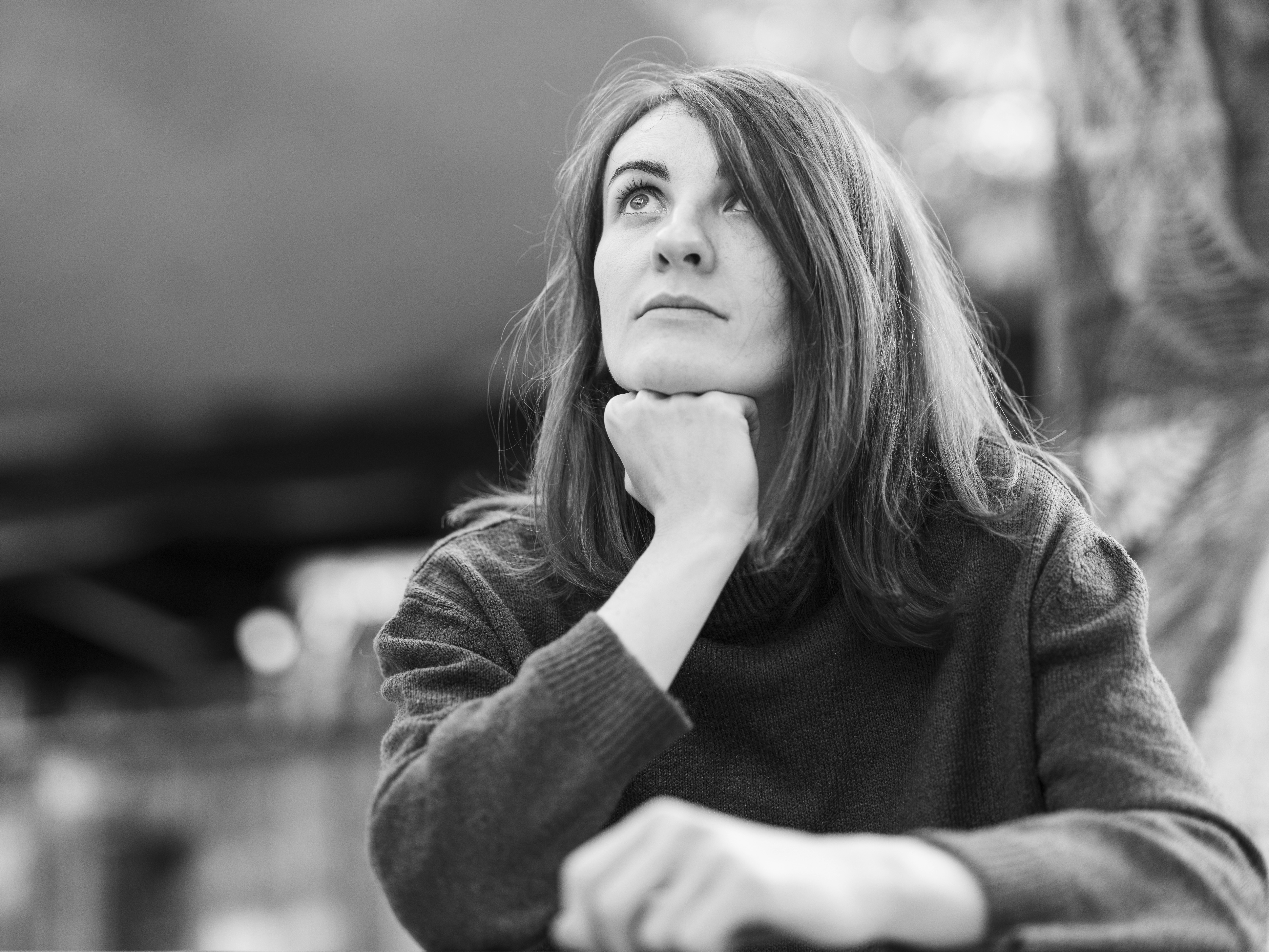 a black and white photo of a woman with her hand on her chin