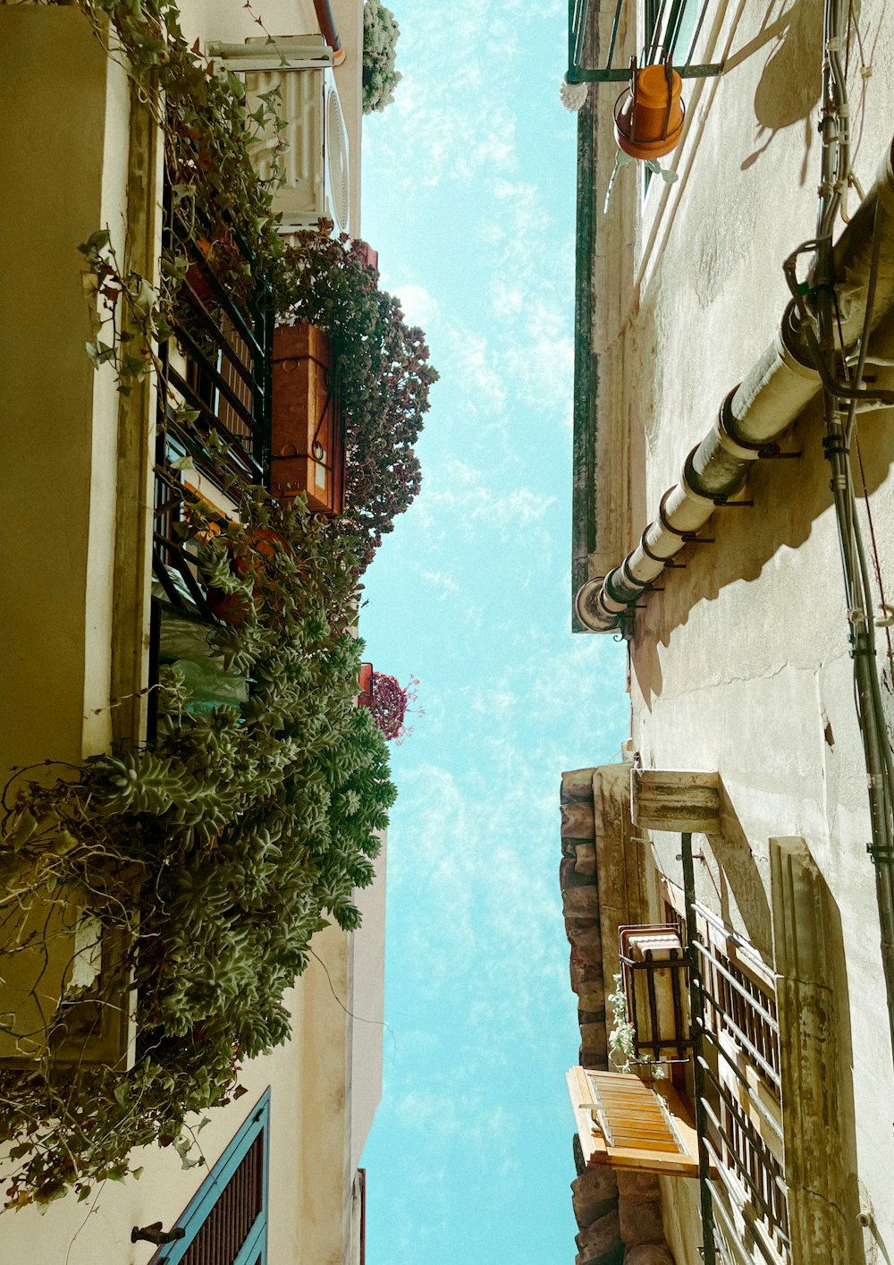 a narrow alleyway with a blue sky in the background