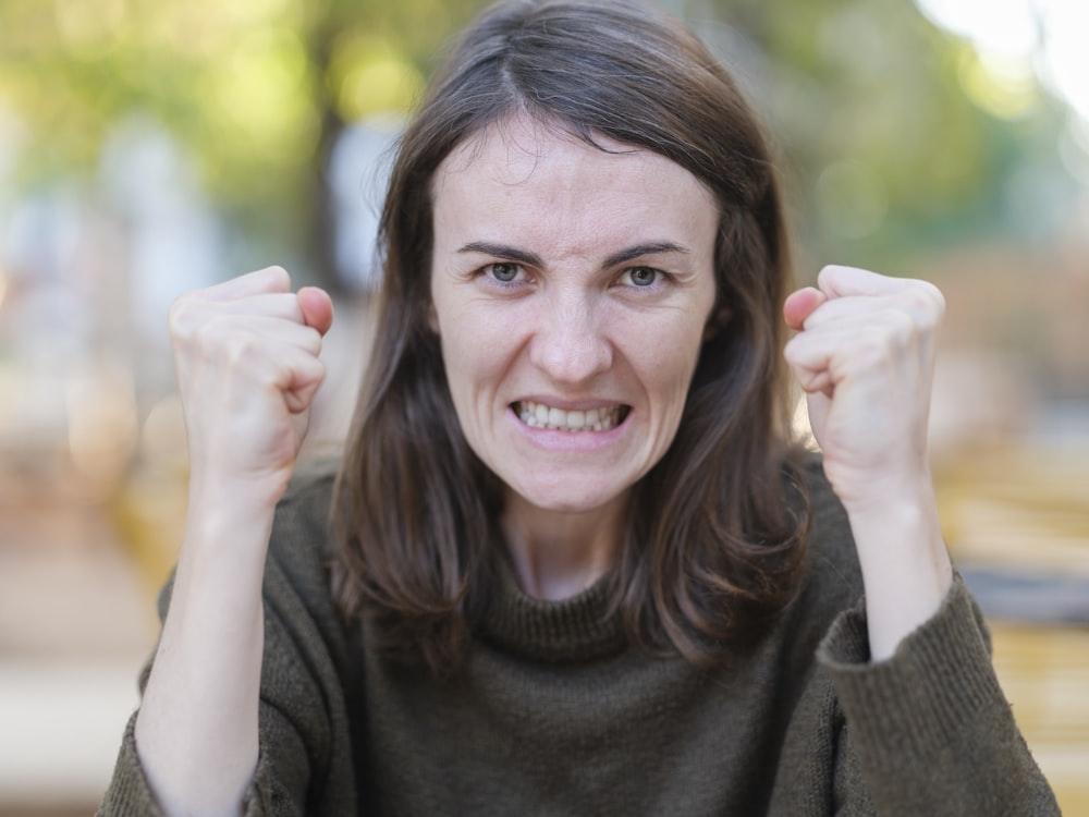 a woman holding her fists up in the air