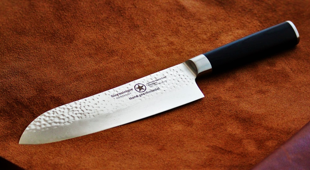 a knife sitting on top of a brown cloth