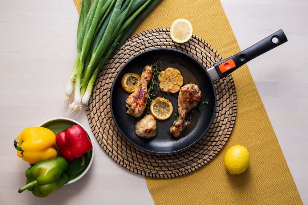 a pan with chicken and lemons on a table