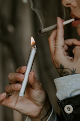 Artistic shot of a lit joint with smoke curling upwards.