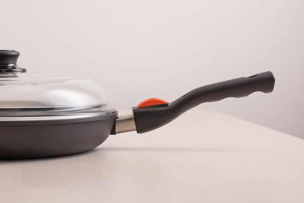 a pan with a lid and a handle on a table