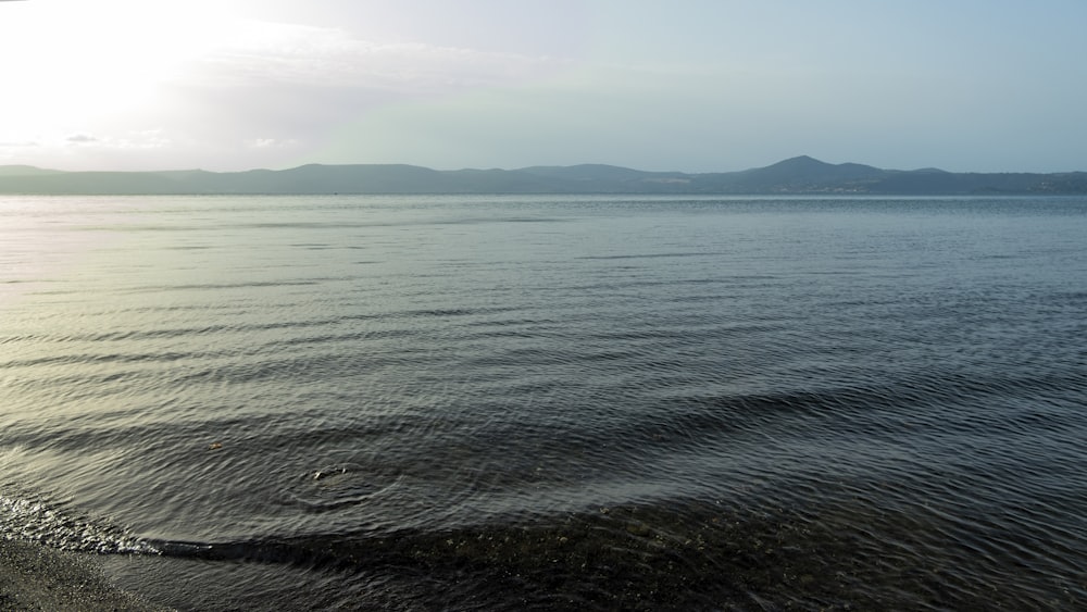 a large body of water sitting under a blue sky