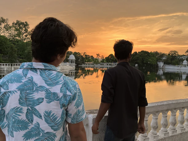 Smiling couple enjoying their stay on a balcony overlooking the peaceful Taj Lake.