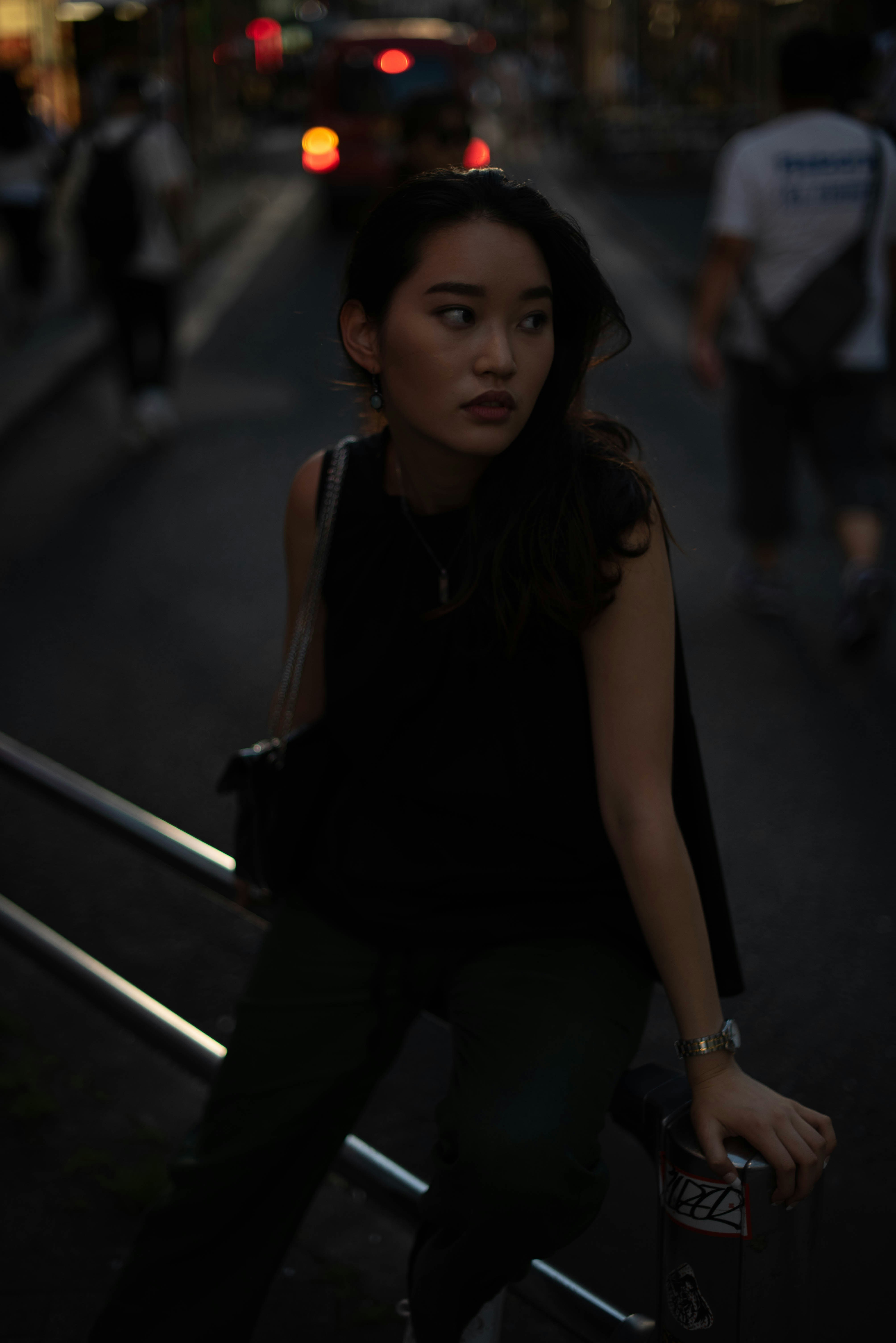 a woman sitting on a railing in the dark