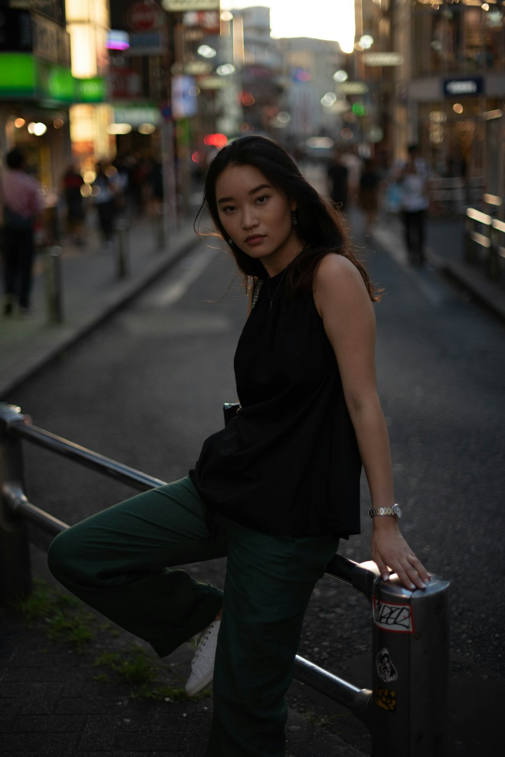 a woman leaning on a rail on a city street