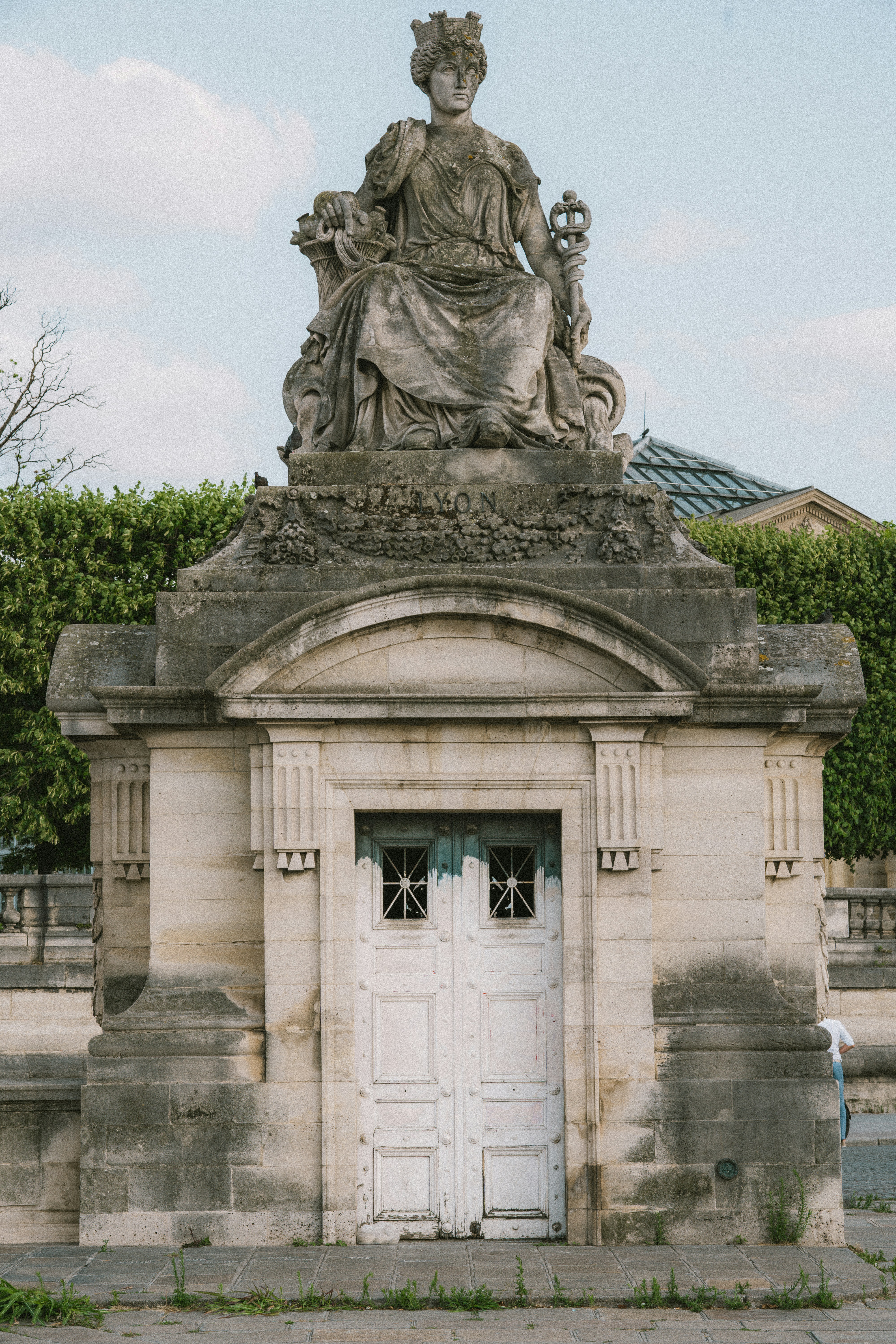 a statue of a woman sitting on top of a white door