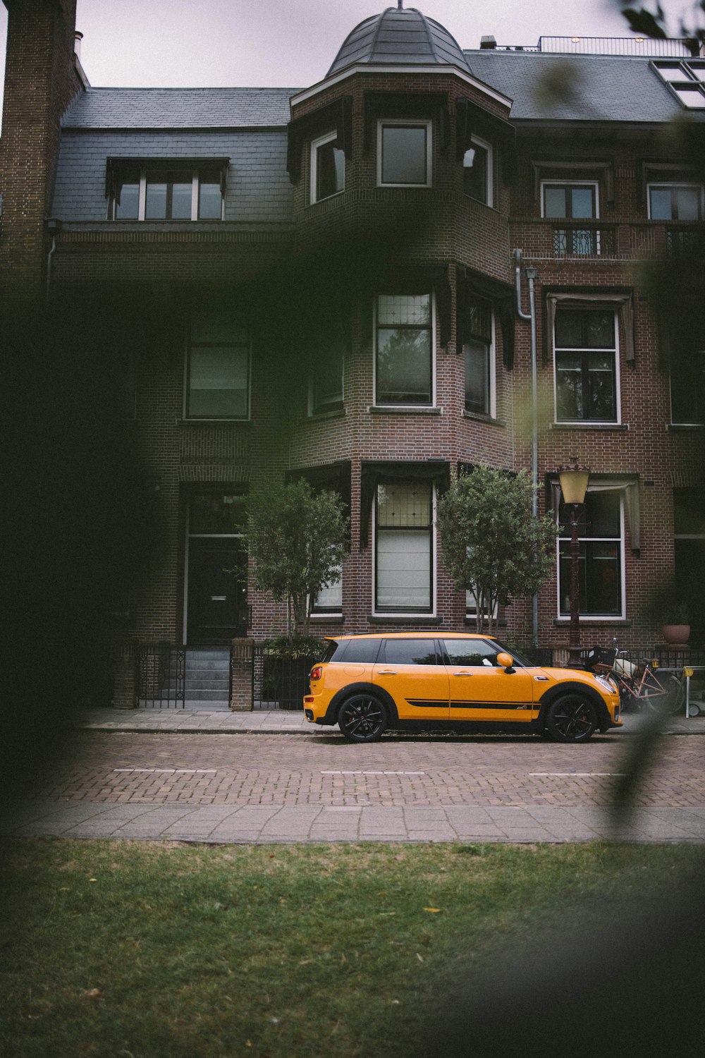 a yellow car parked in front of a tall building