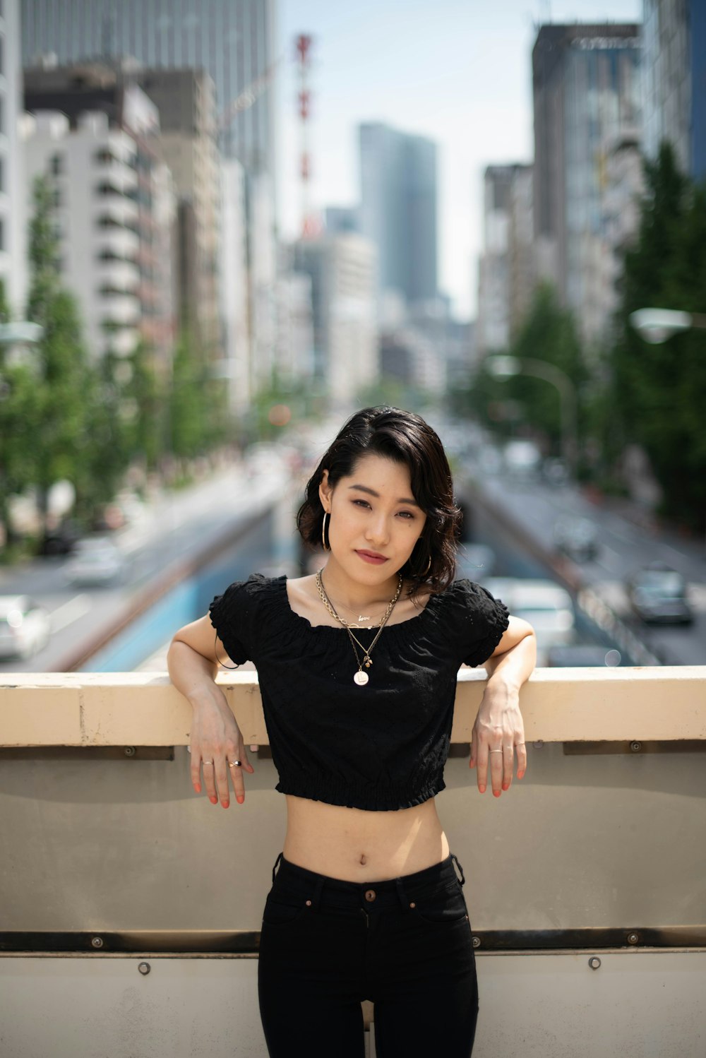 a woman standing on top of a balcony next to tall buildings