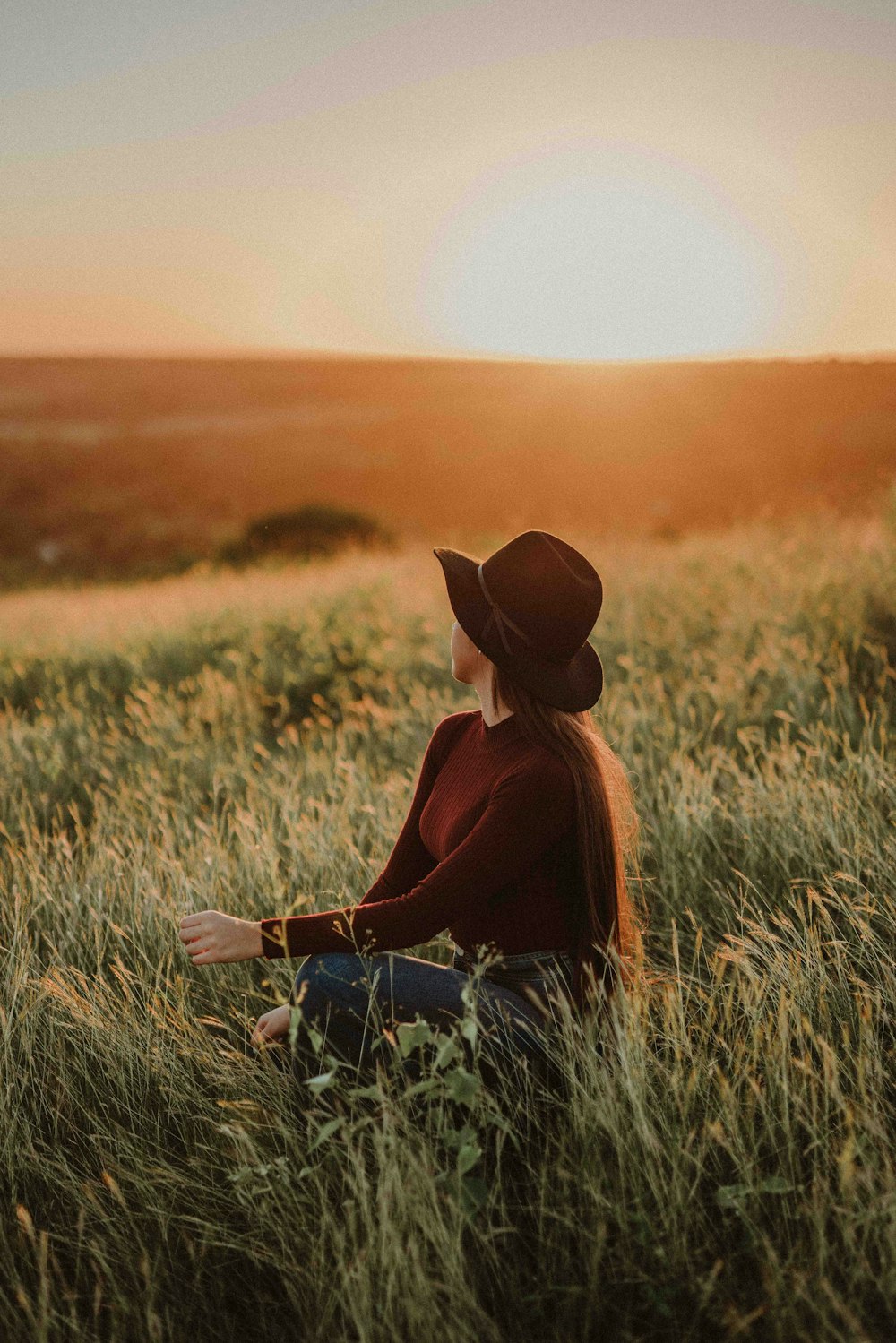 a woman sitting in a field of tall grass