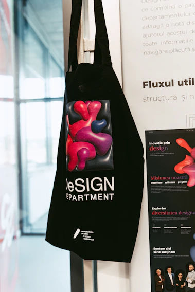 A vibrant tote bag with bold graffiti-style prints resting against a weathered brick wall.