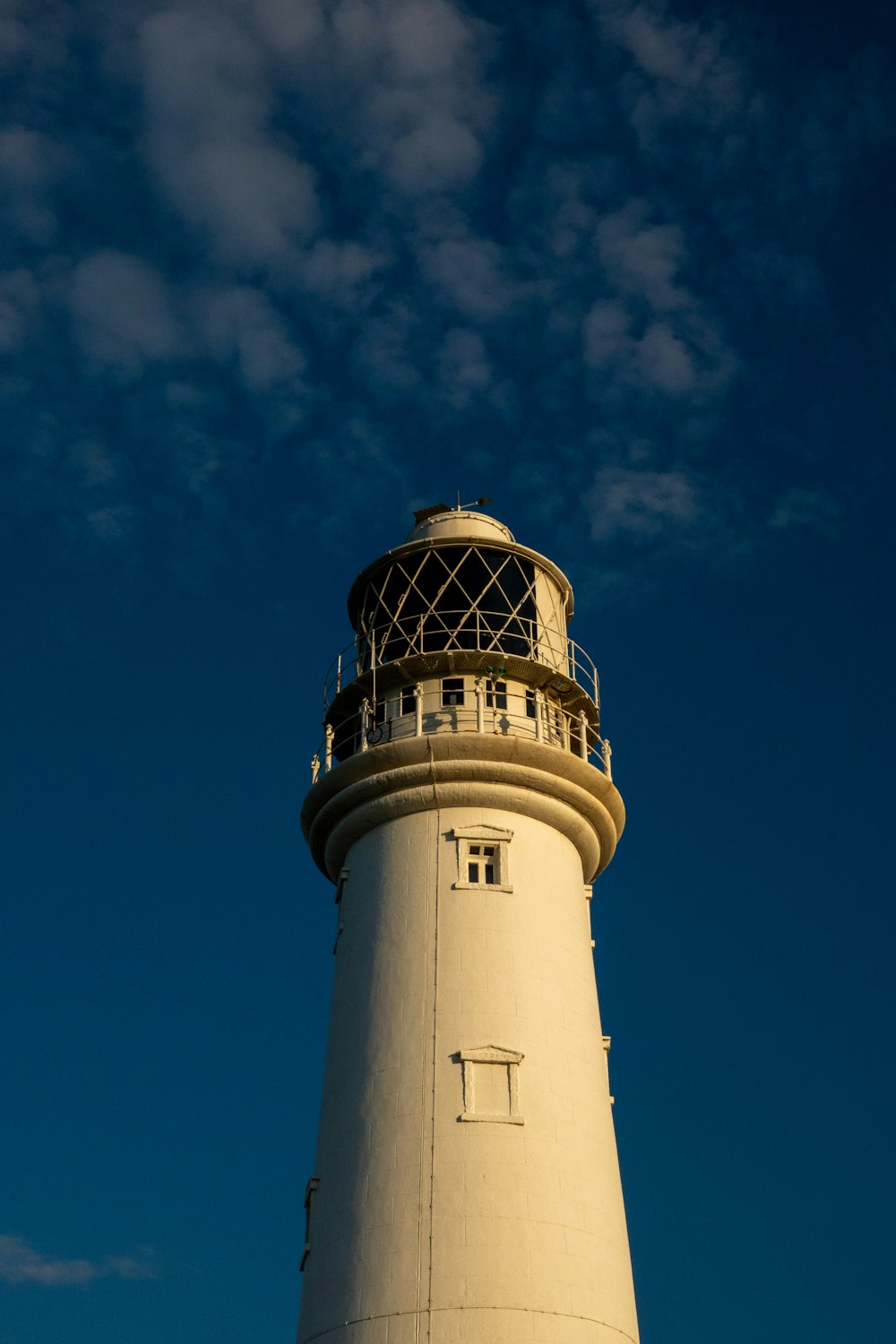 a white lighthouse with a blue sky in the background