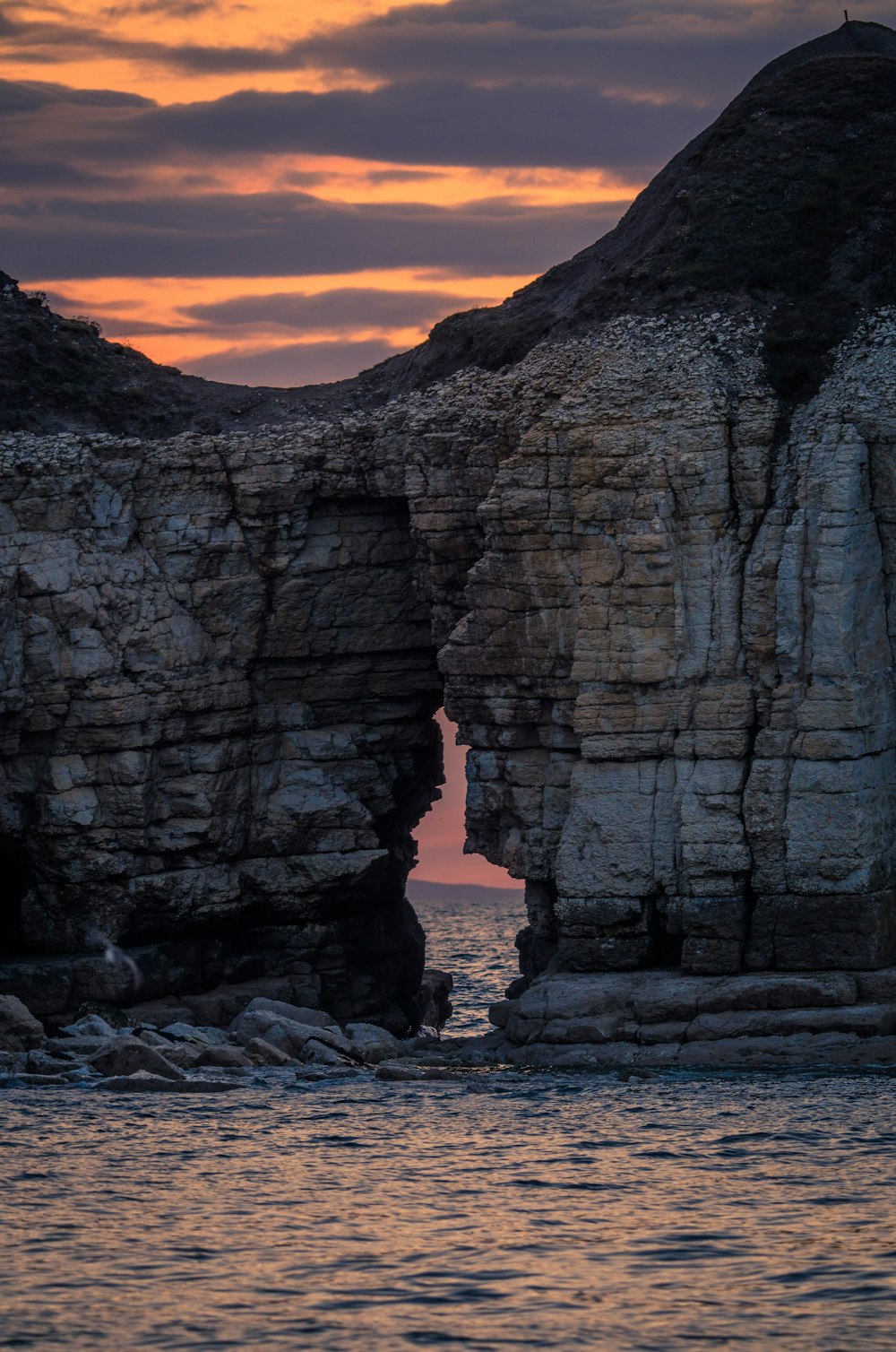 a large rock formation in the middle of a body of water