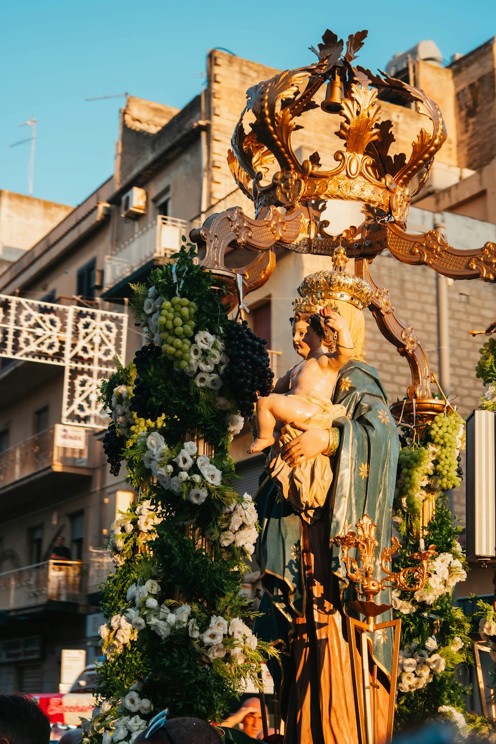 a statue of a person holding a cross in front of a building