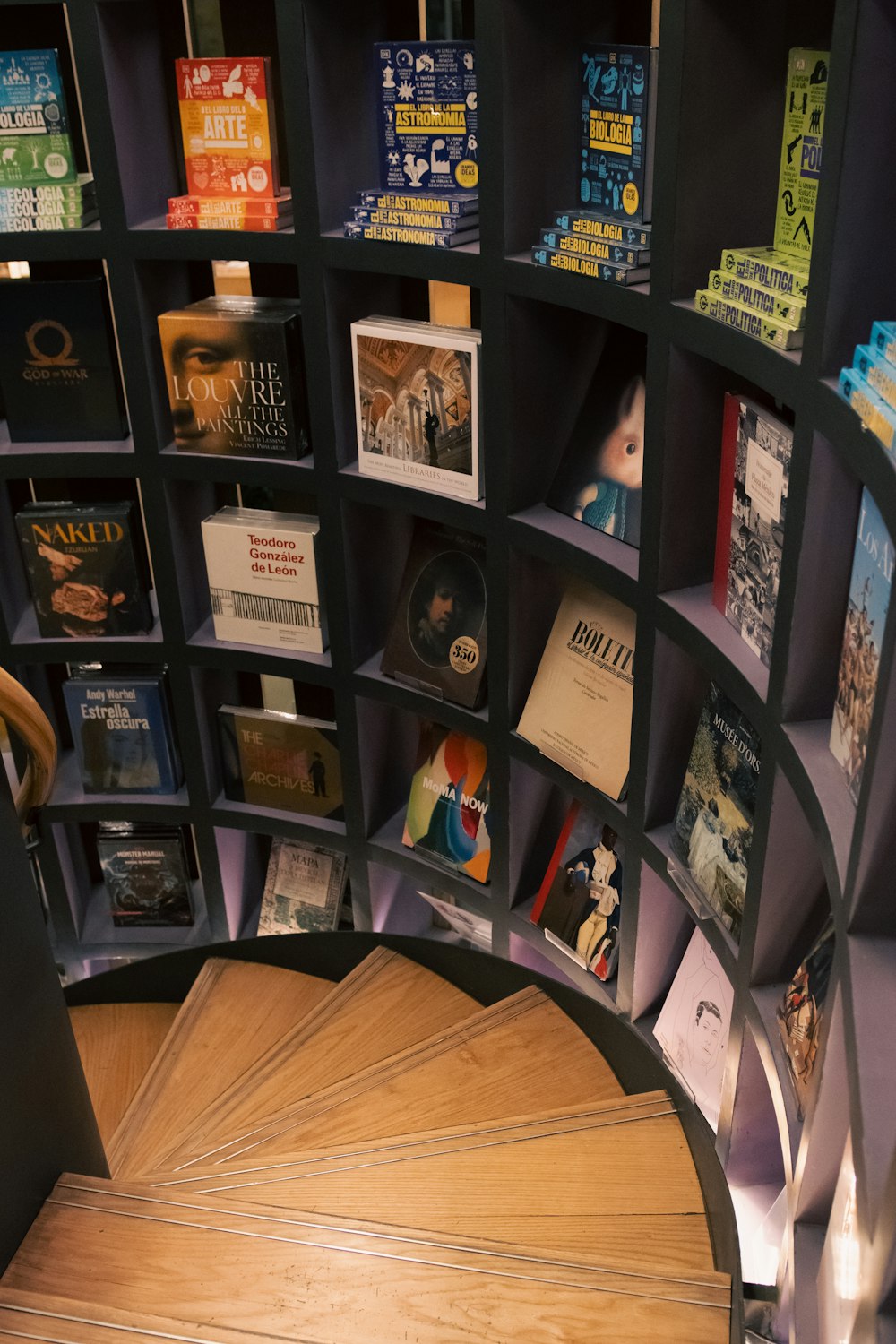 a spiral staircase in a book store with books on the shelves