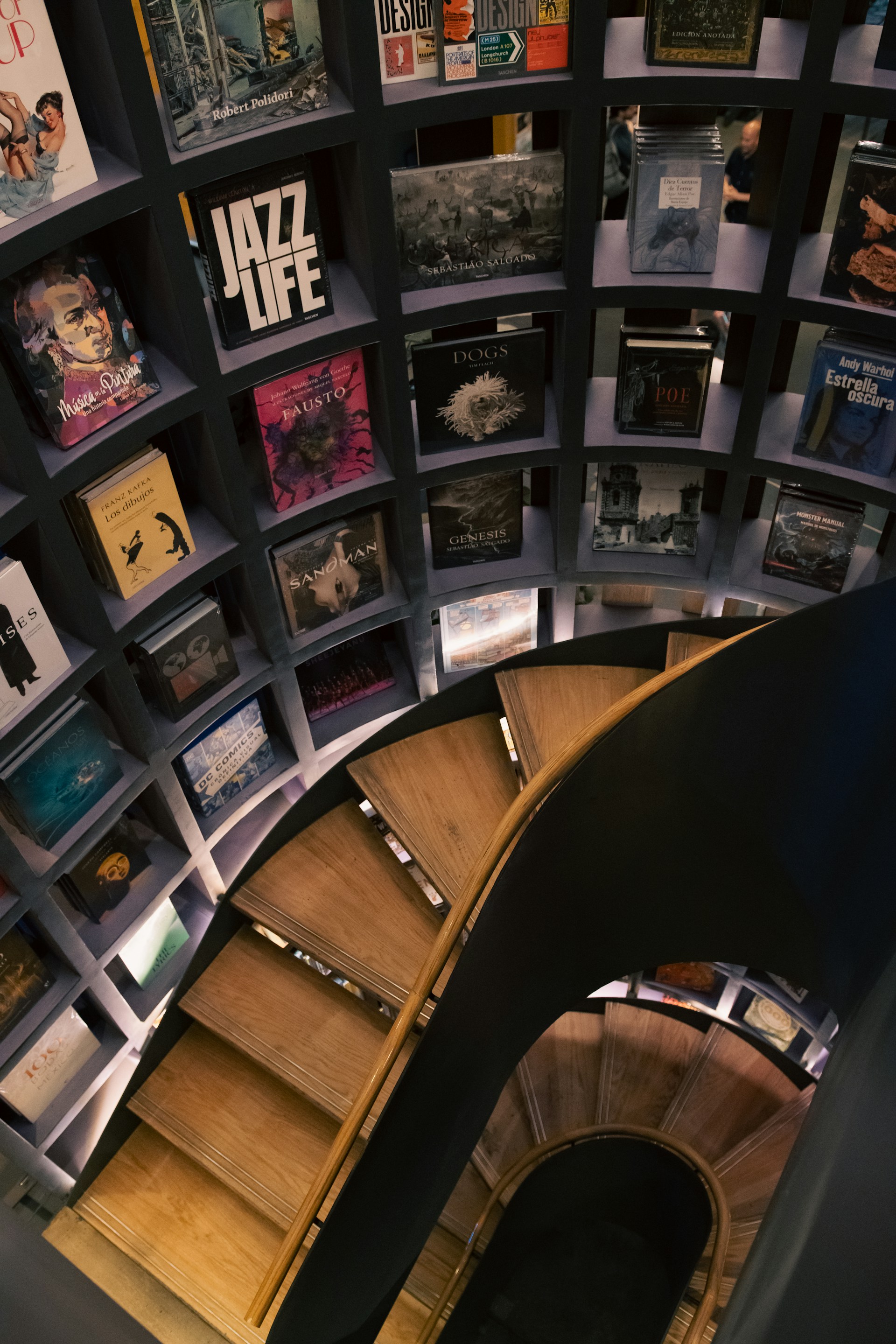 a spiral staircase in a library with bookshelves