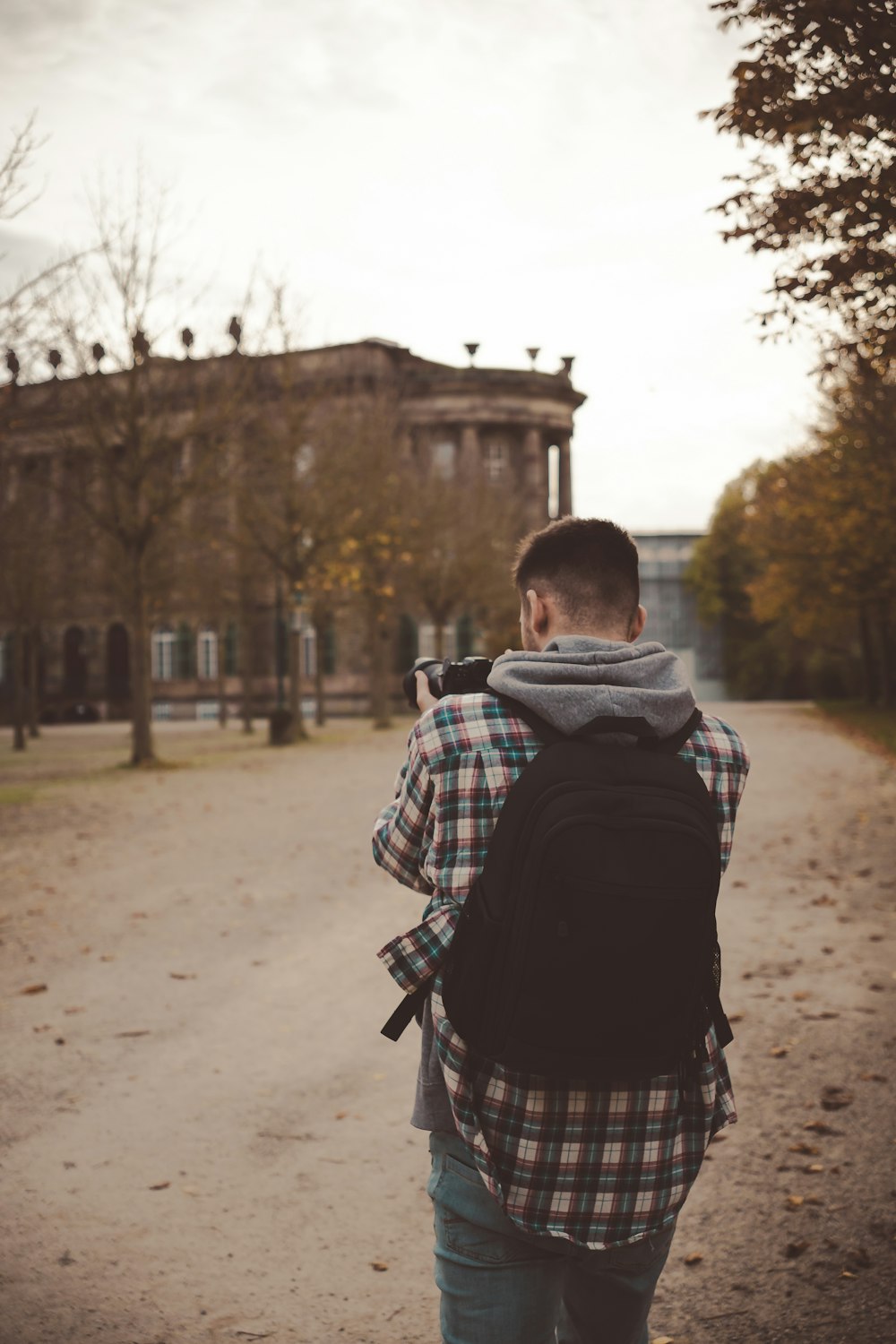 a man with a backpack walking down a dirt road