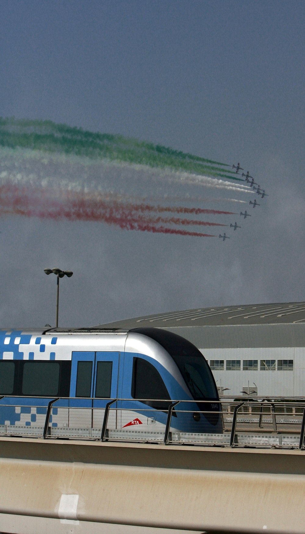 a train on a track with jets flying in the sky