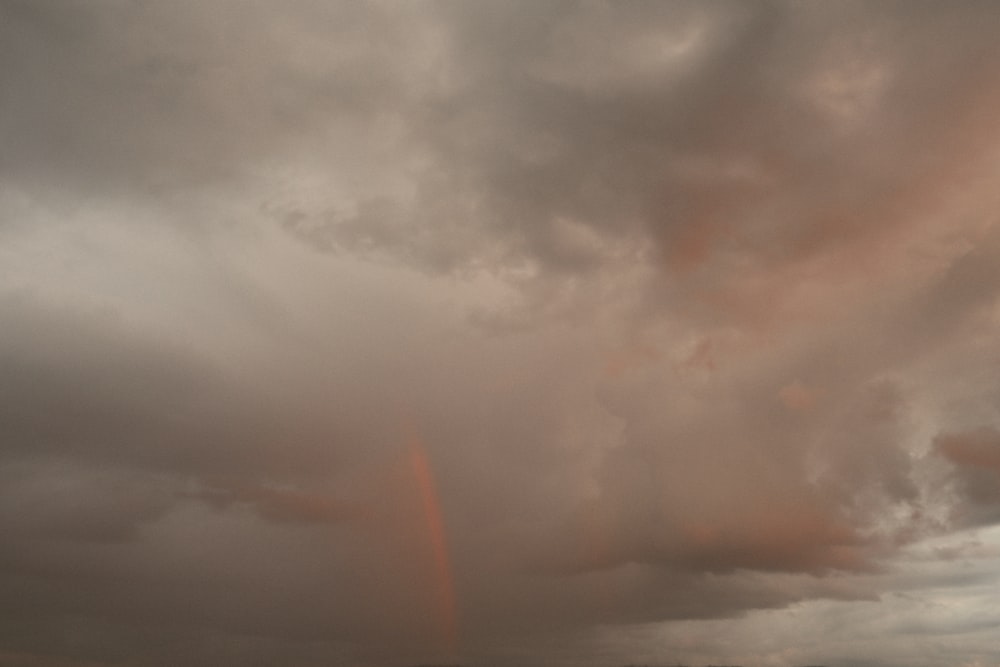 a cloudy sky with a rainbow in the distance