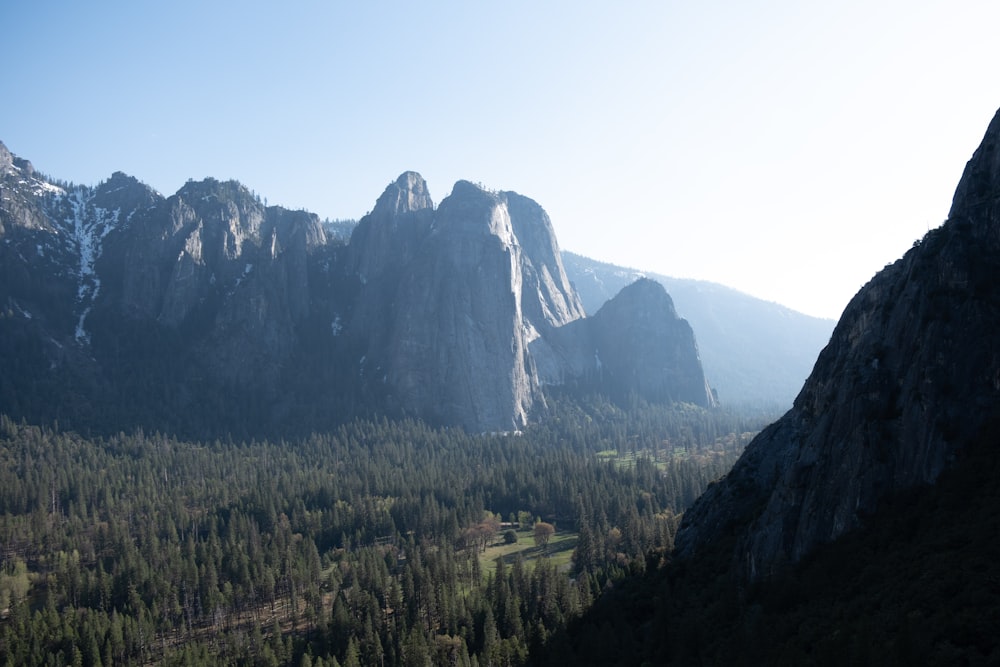 a view of a mountain range with trees and mountains in the background