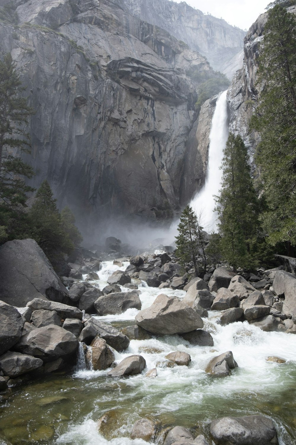 a waterfall in the middle of a river surrounded by rocks