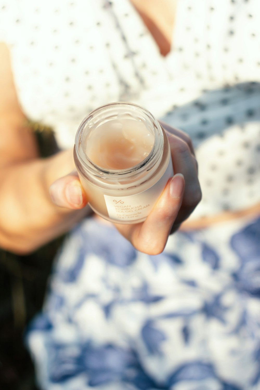 a person holding a jar of liquid in their hand