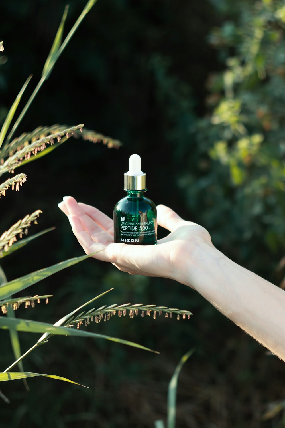 a hand holding a bottle of essential oil