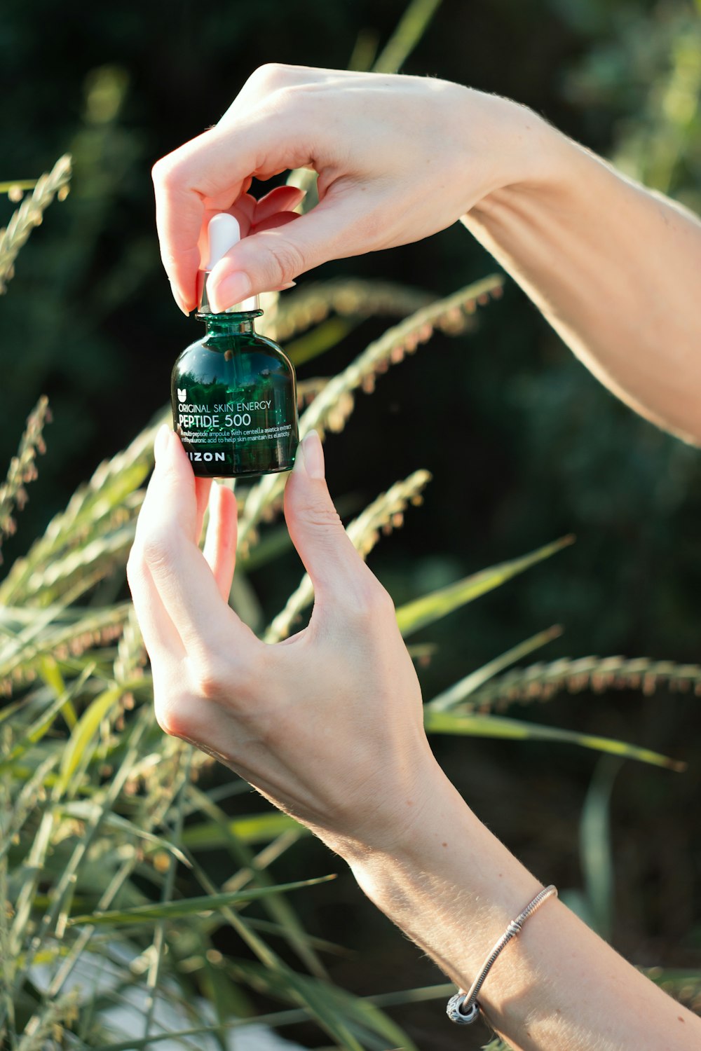 a person holding a bottle of essential oil in their hands